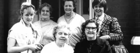 Sue Newton smiles standing next to some of the first PSS Shared Lives carers.