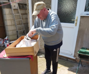 James is out in the back garden on a summers' day upcycling a chest of drawers with a fresh lick of paint